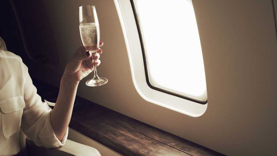 Woman drinking champagne on aeroplane