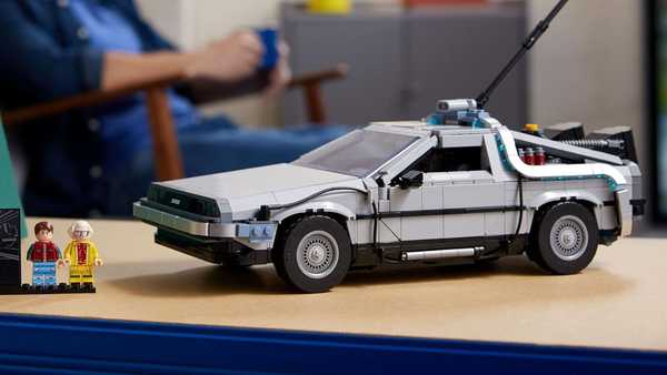 a person sitting at a desk with a toy car