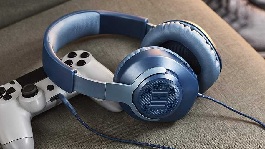 jbl headphones next to gaming controller on couch