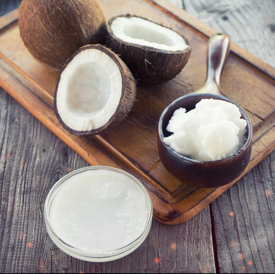 Coconut with coconut oil in jar on wooden background Coconut with coconut oil in jar on wooden background