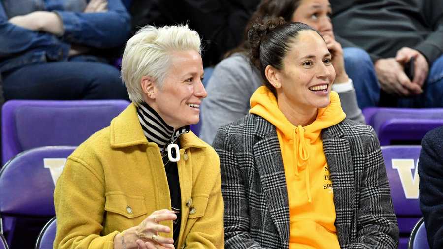 Sue Bird and Megan Rapinoe and sit together in the stands.