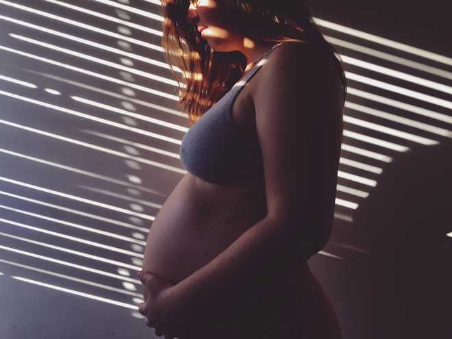 Sunlight&#x20;Falling&#x20;On&#x20;Pregnant&#x20;Woman&#x20;Standing&#x20;By&#x20;Wall
