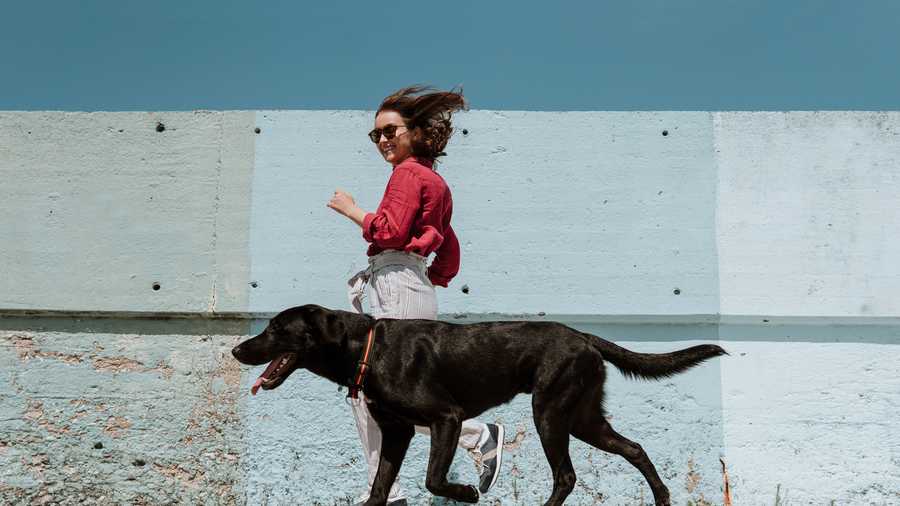 woman running alongside dog