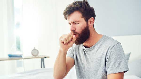 Stock image of a man coughing.
