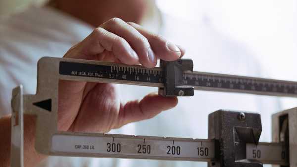 man weighing himself on scale