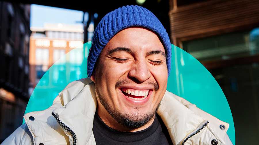 man in blue beanie smiling with eyes closed