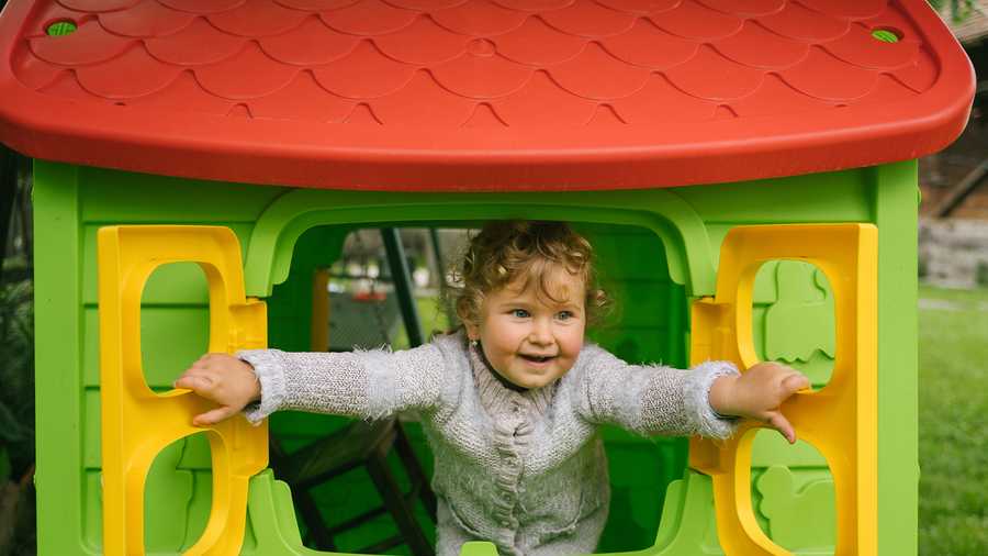 kid opening window of outdoor playhouse