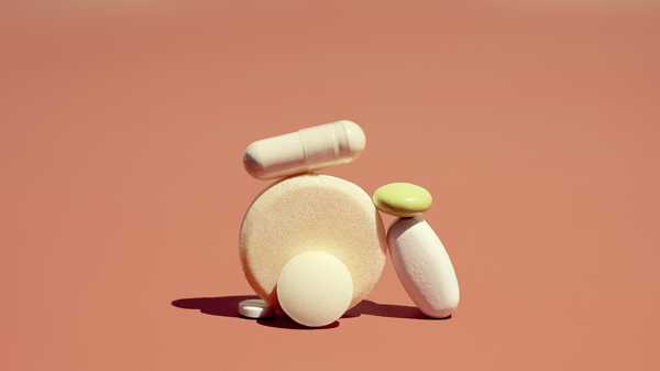 group of vitamins and supplements on orange background