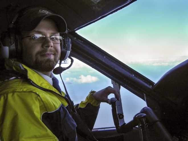 an airplane pilot looks at a camera while flying