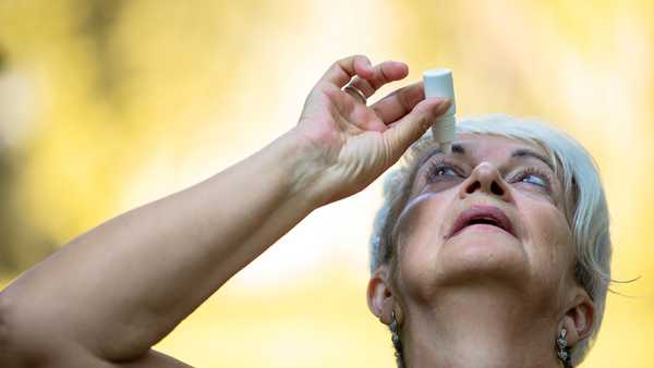 senior woman putting eye drop