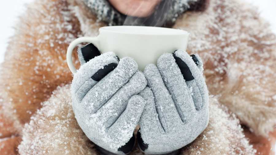 person holding mug in touchscreen gloves