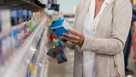 Unrecognizable woman stands in store pharmacy making decision