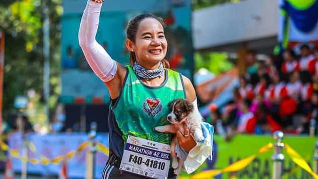 woman runs marathon holding puppy