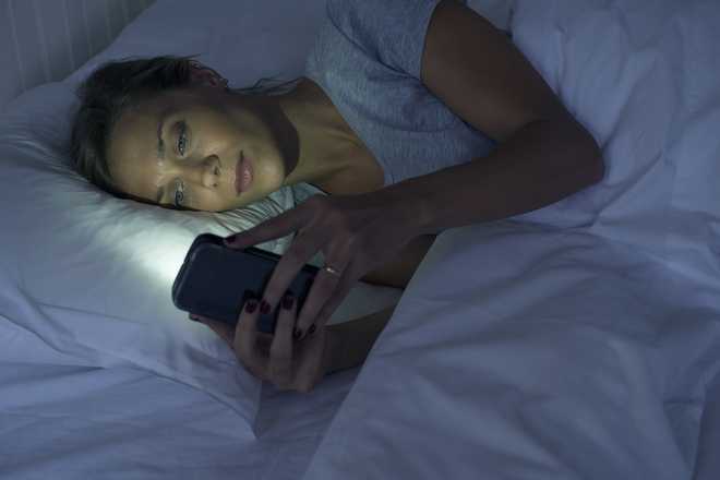 Woman&#x20;lying&#x20;in&#x20;bed&#x20;using&#x20;smartphone