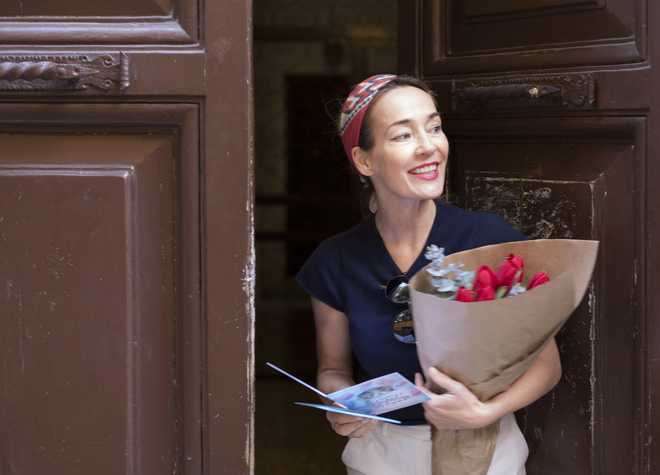 woman receiving a flower bouquet with greeting card