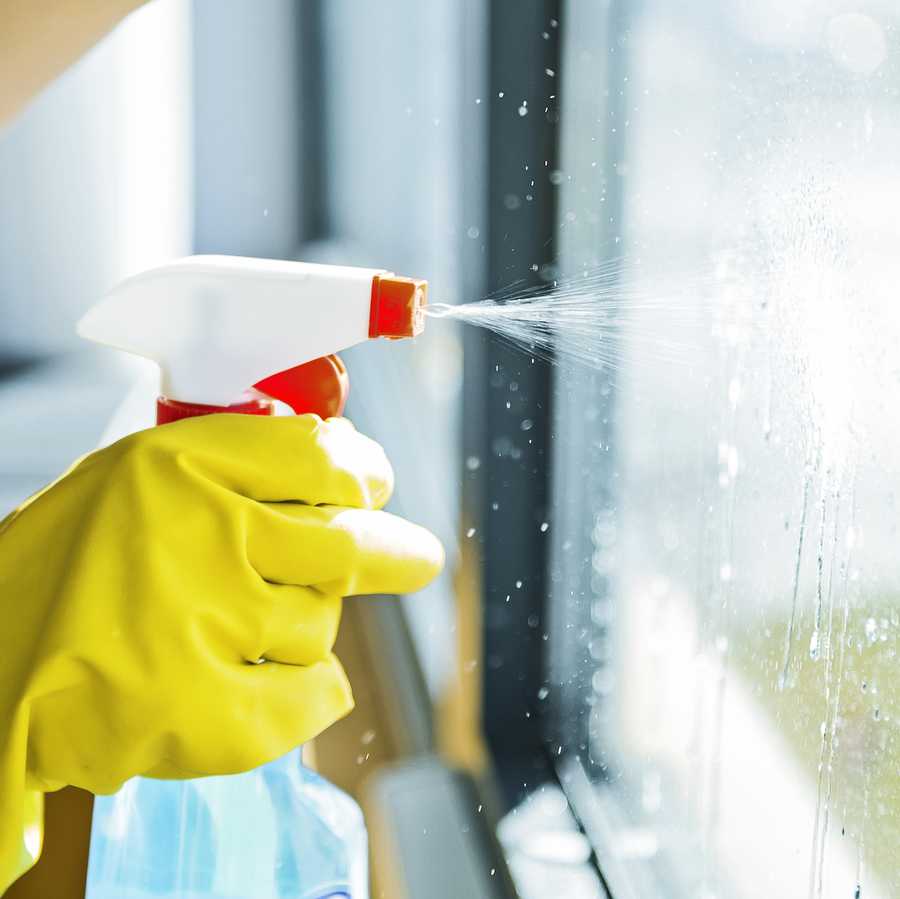 Young woman washing window