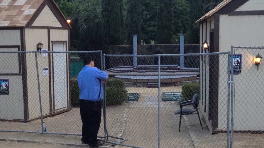 A guard secures a gate outside the Sacramento Shakespeare Festival.