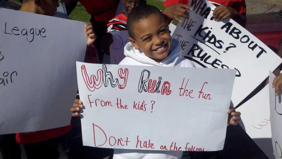 A kid holds up a sign that says "Why ruin the fun from the kids?"during a demonstration Wednesday in support of youth sports in Stockton. 