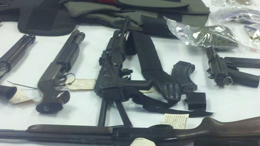 Police officers display some of the weapons they uncovered in the raids.