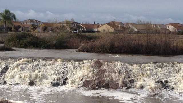 Water runoff from Laguna Creek in Elk Grove goes over artificial falls near Highway 99 on Friday.  (Dec. 12, 2014)