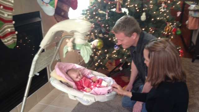 Jason and Kirsti Kinkle look at their daughter Kiira inside their Lincoln home.