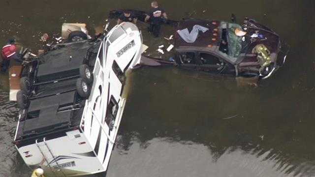 The truck driver was trapped in his vehicle for a short time, but firefighters freed him about 4:15 p.m. The truck and trailer remain in the water. (March 11, 2015)