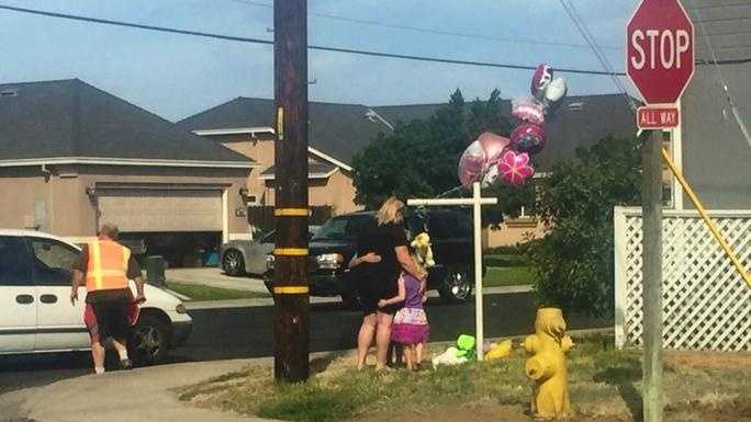 Families near Shasta Elementary School leave flowers and balloons at the crash site where a 6-year-old Manteca girl was killed Friday. (Sept. 25, 2015)