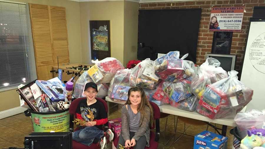 Danny Fry, 7, and Bailey Stone, 9, helped collect toys for the V.B.R. Foster Family Agency toy drive. The two children smile for the camera on Wednesday, Dec. 23, 2015, in front of the toys they collected so far.
