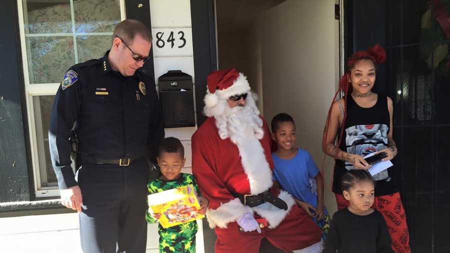 Stockton Police Chief Eric Jones poses with Santa and a family on Friday, Dec. 25, 2015. The Stockton Police Department delivered presents to families and children affected by violent crime this year.