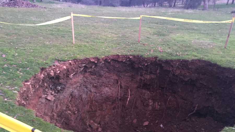 A sinkhole opened up on a Jackson, Calif. ranch Sunday, Jan. 24, 2016. By Monday, the property owner marked off the area with wooden sticks and caution tape.