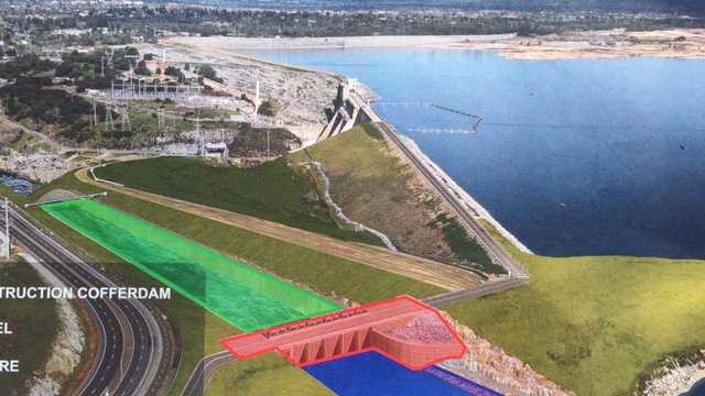 Water is now being held back by the new auxiliary dam (in red). Crews will soon begin removing the temporary construction dam (in yellow). By the end of the year, work will be complete on the downstream chute (in green.)