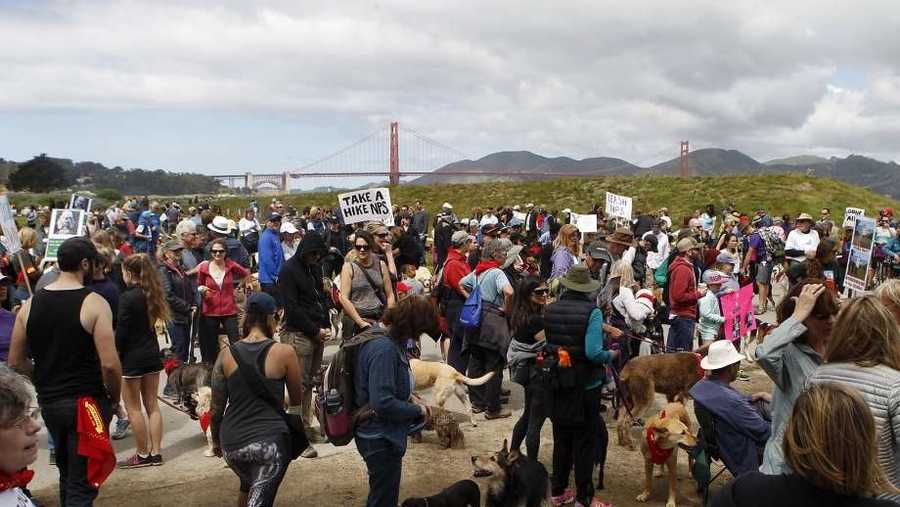 The protesters on Saturday walked their four-legged pooches, many wearing red bandanas, along Crissy Field while holding signs that read "Unleash Our Land!" and "Put Feds On A Leash!"