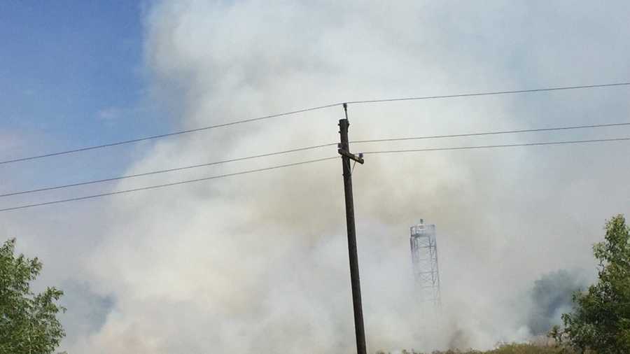 Firefighters say grass fire is growing but not structures threatened.