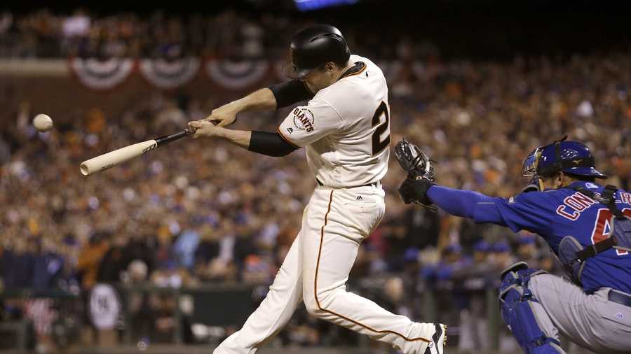 San Francisco Giants' Conor Gillaspie, left, hits a two-run triple in front of Chicago Cubs catcher Miguel Montero during the eighth inning of Game 3 of baseball's National League Division Series in San Francisco, Monday, Oct. 10, 2016.