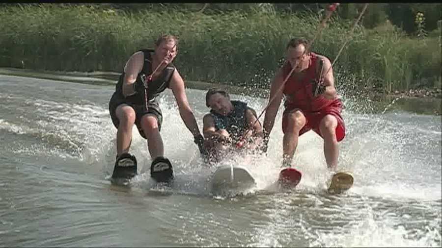 Volunteers help people go from wheelchairs to water skis