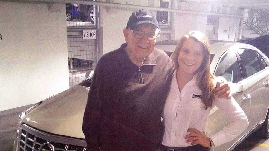 Billionaire investor Warren Buffett poses with saleswoman Madison Willers and his new 2014 Cadillac XTS.
