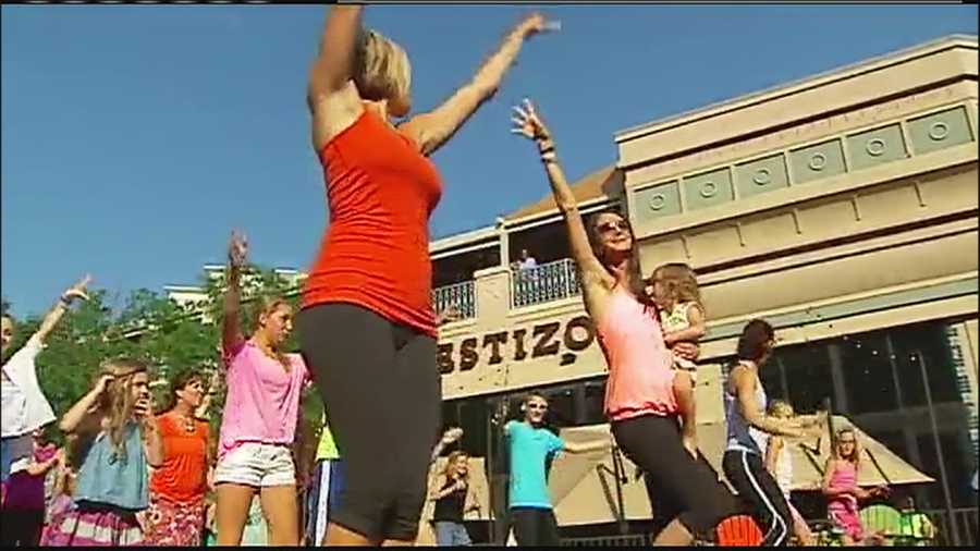 The clients and friends of a Kansas City-area fitness studio put together a flash mob Thursday to help rally around the owner as she fights cancer.