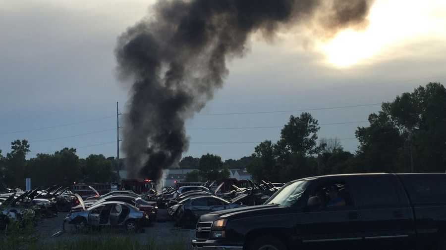 Car fire at scrap yard sends black smoke into the air