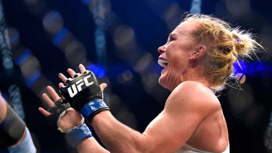 Holly Holm celebrates after defeating Ronda Rousey during their UFC 193 bantamweight title fight in Melbourne, Australia, Sunday, Nov. 15, 2015. (AP Photo/Andy Brownbill)
