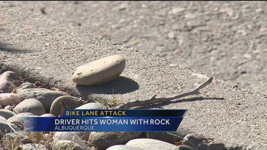 A woman is talking about a traumatizing attack that happened while she was riding her bike. She says someone in a moving car threw a rock out the window, hitting her in the face.
