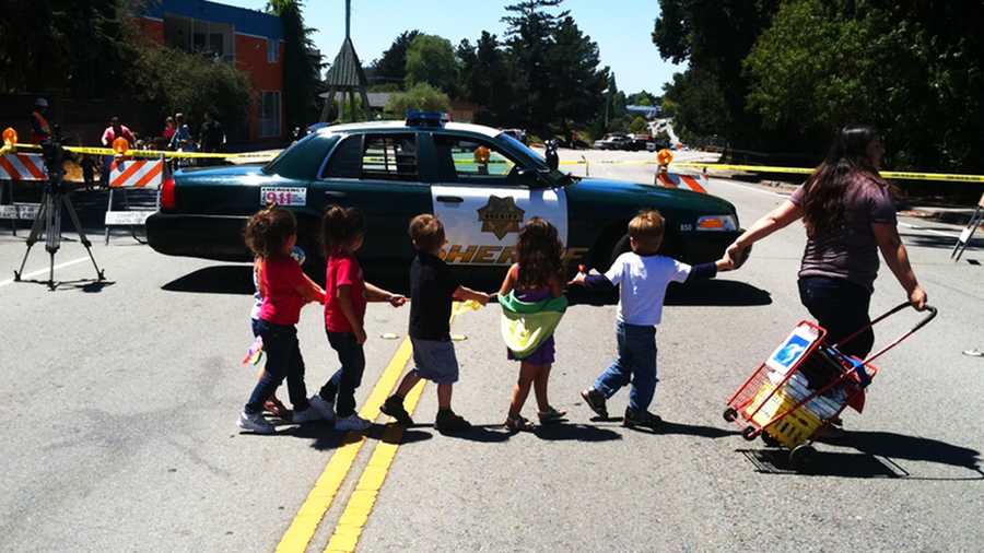 Preschool students are curious as they are escorted away from their school because of a gas leak. (Aug. 7, 2012)