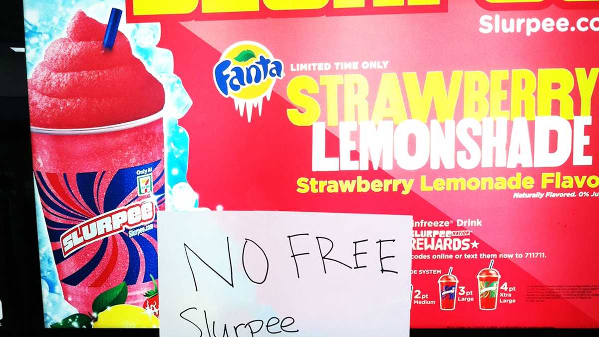 A Slurpee lover displays her free drink outside a 7-Eleven store