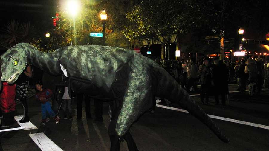 A woman wearing a giant dinosaur costume walks down Pacific Avenue in Santa Cruz. (Oct. 31, 2012)