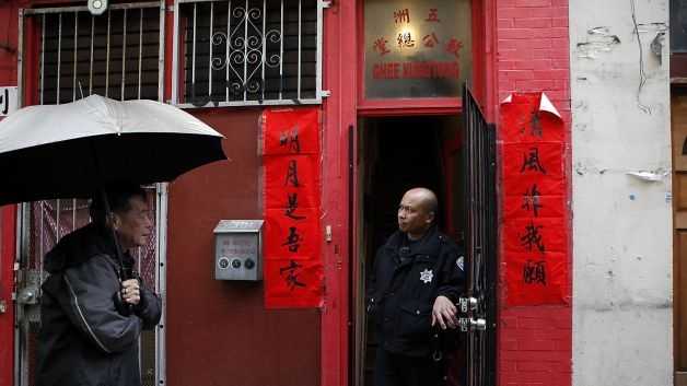 An SFPD officer is seen in the doorway of the Ghee Kung Tong Chinese Free Masons Temple in San Francisco's Chinatown on Mar. 26, 2014.