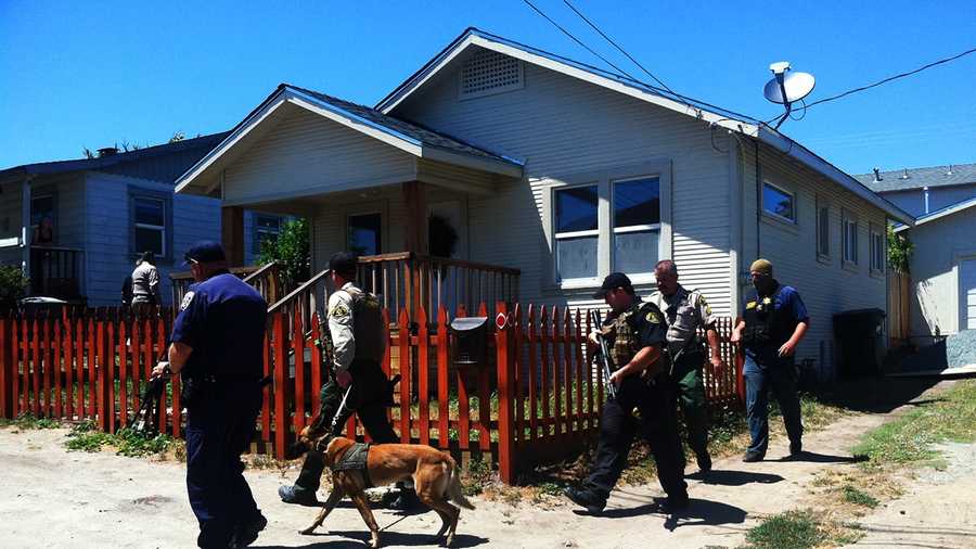 Investigators are seen here searching several houses down from where a standoff happened on Deer Place. (May 27, 2014)
