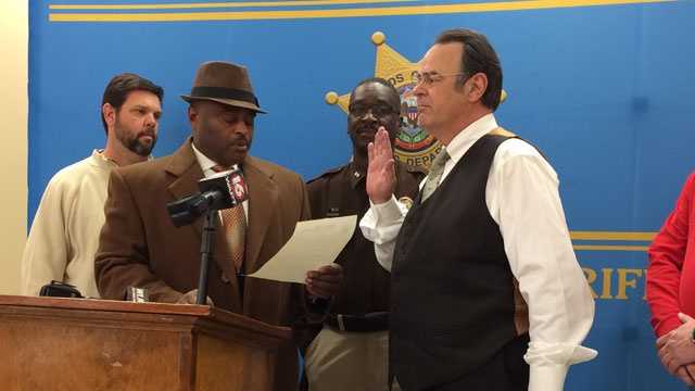 Actor and comedian Dan Aykroyd is sworn in as an honorary deputy by Hinds County Sheriff Tyrone Lewis.