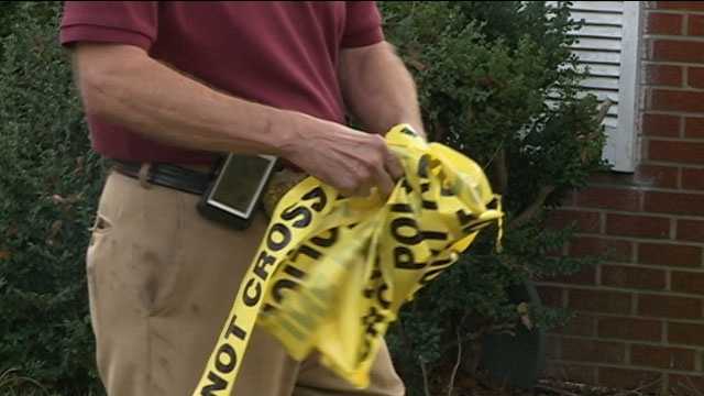 An investigator removes crime scene tape
