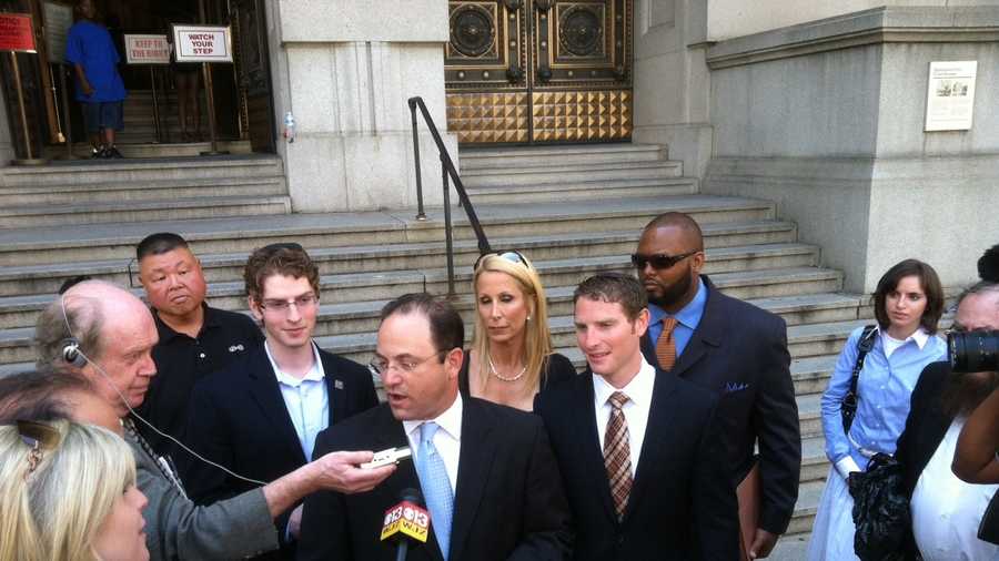 Family attorney Andrew Alperstein speaking to the media after Eli Werdesheim's sentencing. Werdesheim is seen to the right of Alperstein (wearing the suit and brown tie). His brother, Avi, who was acquitted in the trial, stands to the left of Alperstein.
