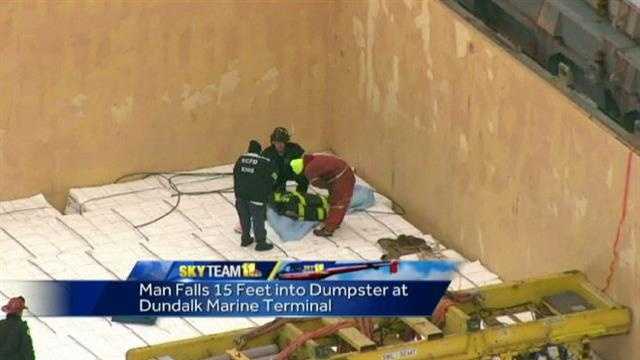Crews work to rescue the man after he fell into a dumpster on a ship.