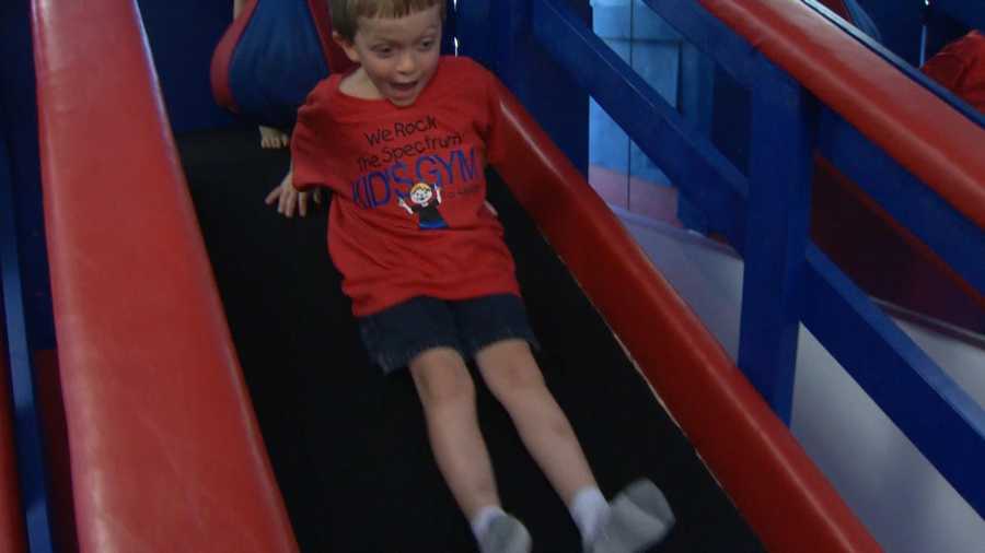 Kyle Alton, 6, goes down a slide at We Rock the Spectrum gym in Severna Park.